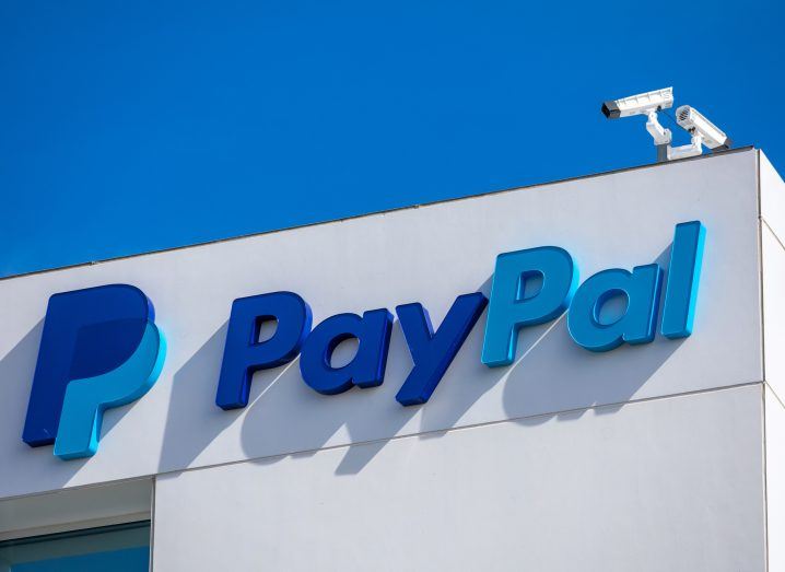 PayPal logo on a building with a blue sky in the background.