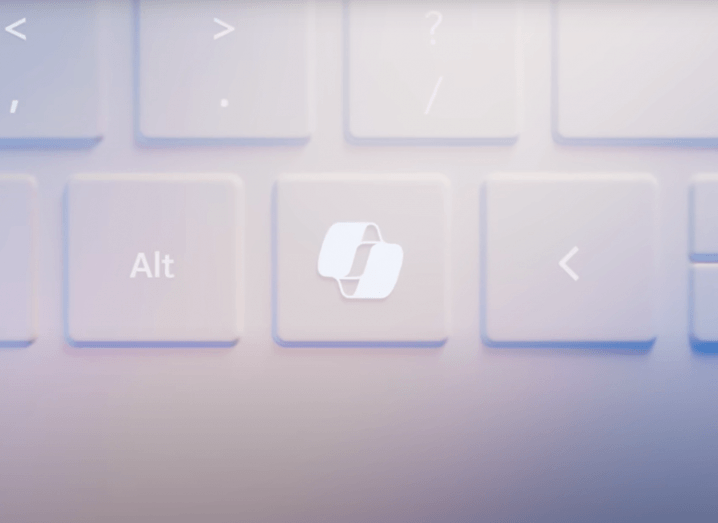 An image of a light pink computer keyboard with the new Microsoft Copilot key placed in the middle between the alt key and the left arrow key.