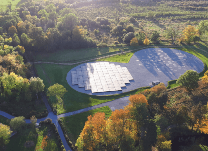 An aerial view of a LOFAR telescope structure on the ground, surrounded by trees.