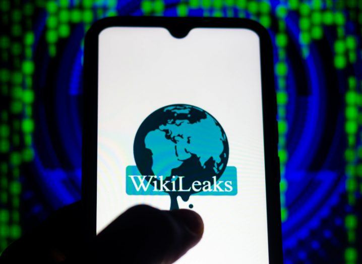 The WikiLeaks logo on a smartphone screen, with green code in the background.
