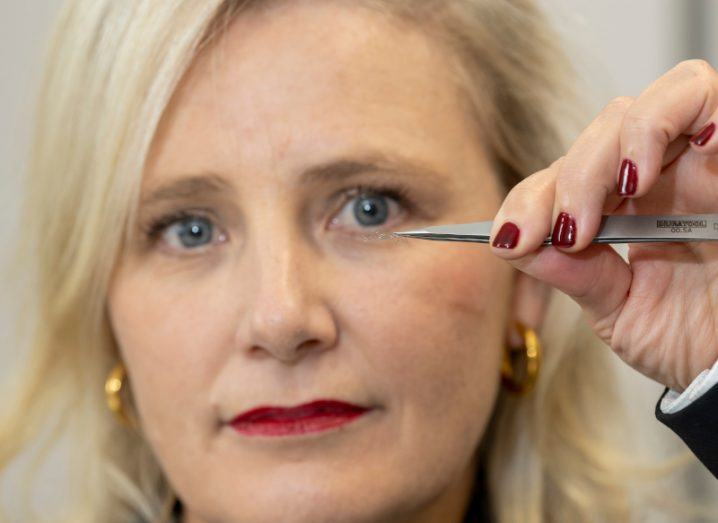 A close-up of a woman holding a small medical device. She is Chloe Brown, CEO of Ceroflo.