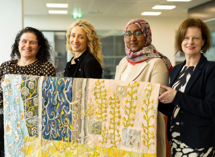 Four women holding a large cloth with different patterns on it. They were representing a project funded by the SFI Discover Programme that aims to improve diversity in STEM.