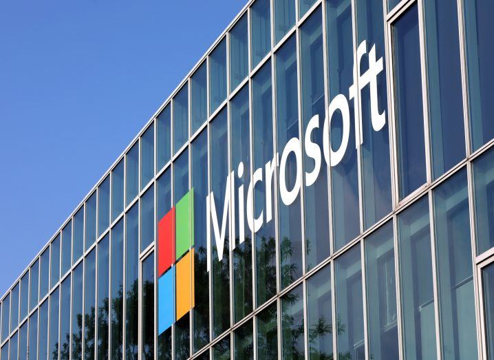 Microsoft logo on a glass building. The blue sky can be seen in the background.