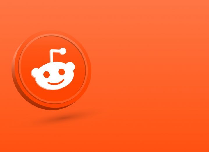 Reddit logo, which is an alien-like face with a crooked antenna coming out of its head, in a deep orange background.