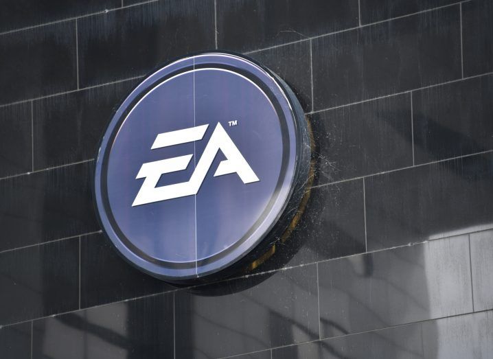EA logo on a black wall with a brick design.