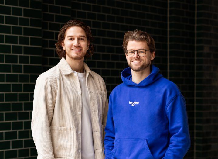 Two men, both founders of Heyflow, stand next to each other for a photo.