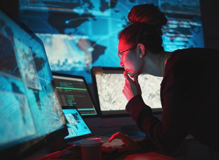 Woman leans in to stare at computer screen after seemingly falling victim to a ransomware attack.