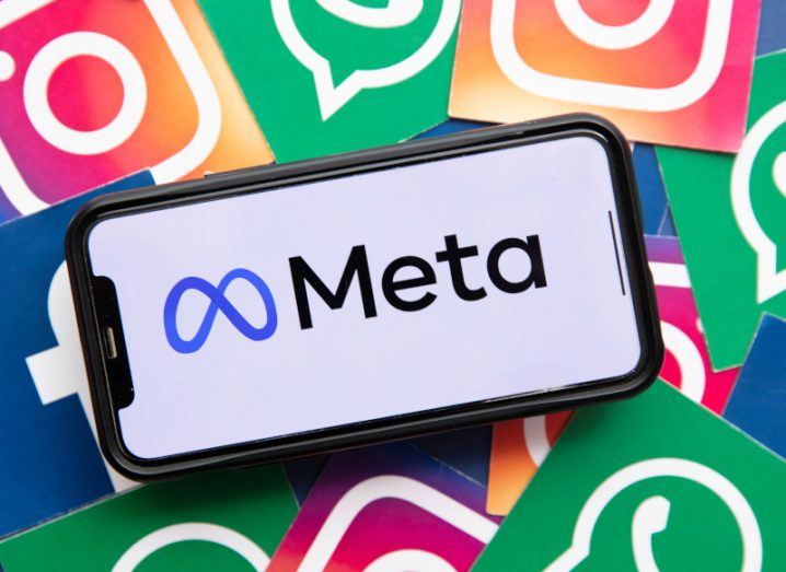 The Meta logo on the screen of a smartphone, laying on top of Facebook, Instagram and WhatsApp logos.
