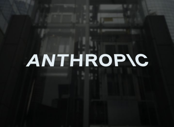Anthropic logo on a building reflecting other tall buildings.