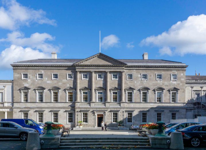 Leinster House with cars and people in front of it.
