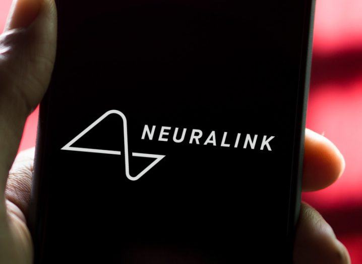 The Neuralink logo on the front of a smartphone screen.