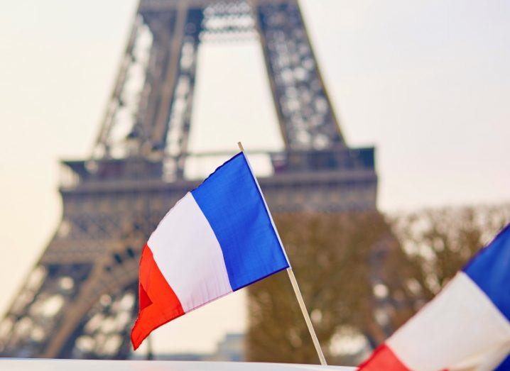 Two French flags in front of the Eiffel Tower.