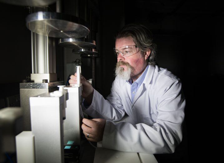 A researcher in a dark room working with lab equipment.