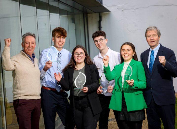 Multiple students from the BT Young Scientist Business Bootcamp holding awards and standing next to a UCD Professor and a BT Ireland managing director.
