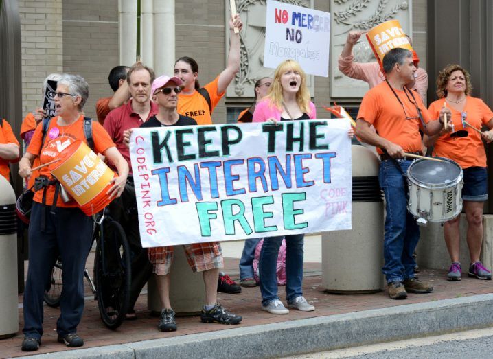 A group of net neutrality supporters protesting, holding a sign that says 'keep the internet free".