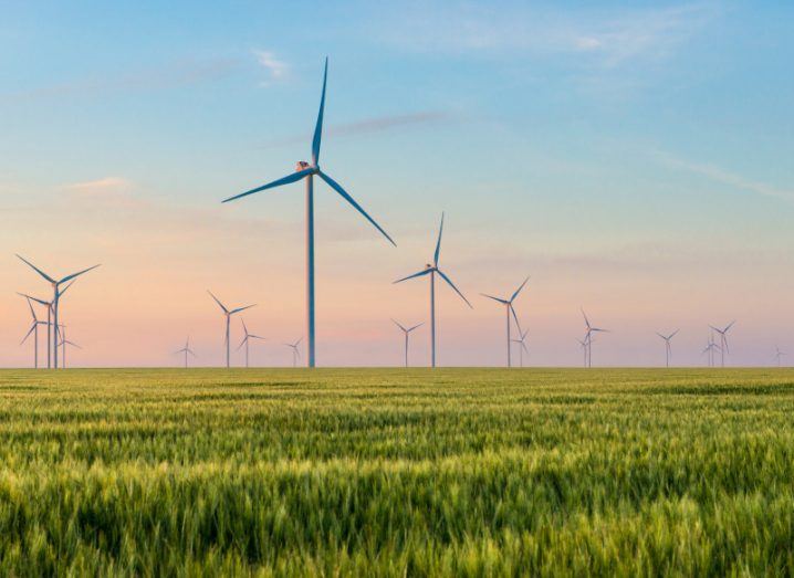 Various wind turbines on a green field.