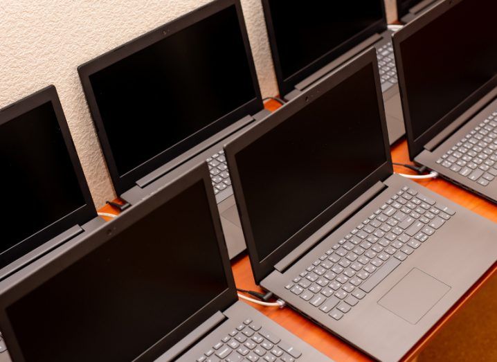 Multiple laptop PCs on a wooden table.