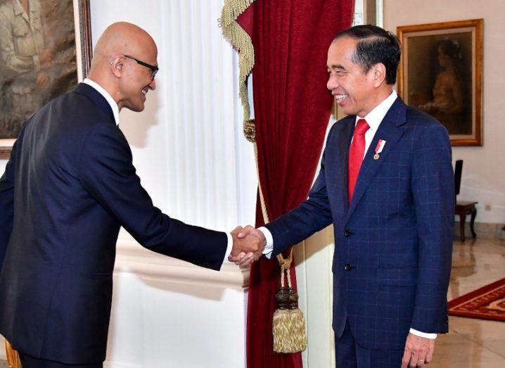 The CEO of Microsoft shaking hands with the president of the Republic of Indonesia in a room.