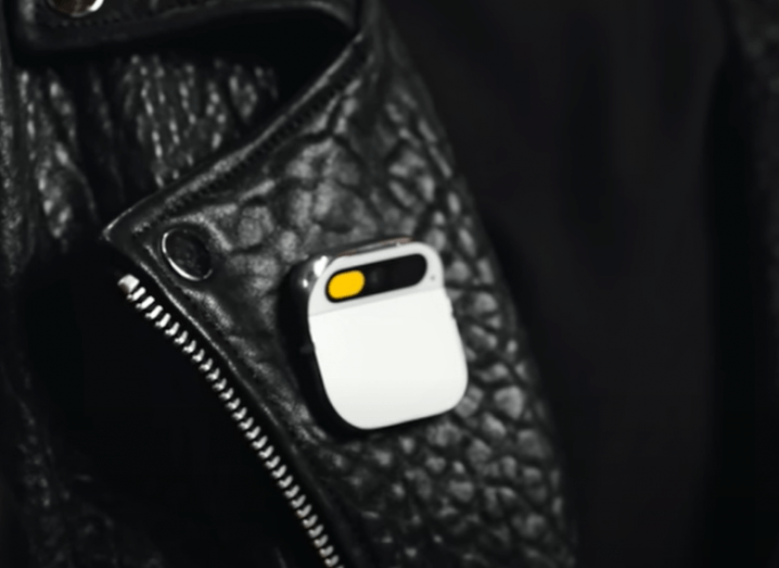 The Humane AI pin on the front of a black jacket.
